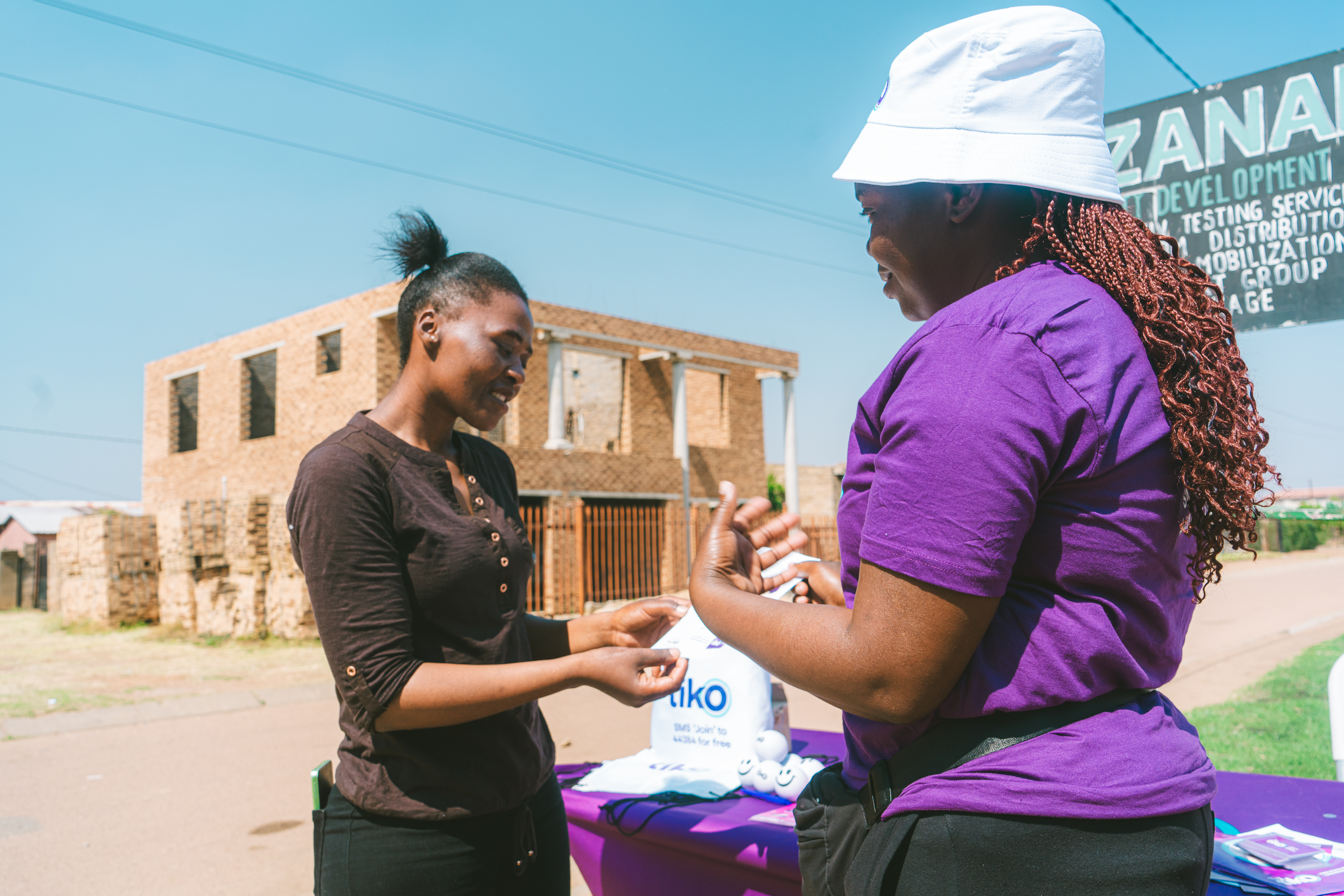 A Tiko mobiliser talks to a young woman about sexual and reproductive health in an urban area in South Africa